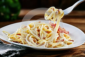 Tasty Italian carbonara spaghetti twirled on a fork photo