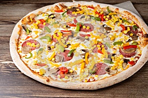 Tasty Italian pizza Mexicano on wooden background. Top view of hot pizza with chili pepper , hot sausages, onion