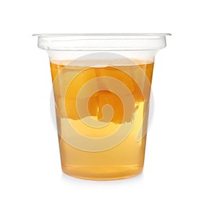 Tasty jelly dessert with slices of fruit in plastic cup on white