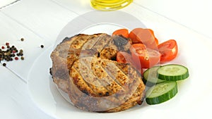 Tasty juicy fresh slices of grilled steak entrecote pork meat next to cherry tomatoes and fresh vegetables cucumbers on