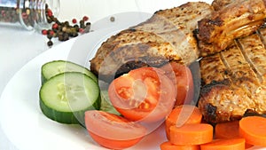 Tasty juicy fresh slices of grilled steak entrecote pork meat next to cherry tomatoes and fresh vegetables cucumbers on
