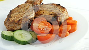 Tasty juicy fresh slices of grilled steak entrecote pork meat next to cherry tomatoes and fresh vegetables cucumbers on