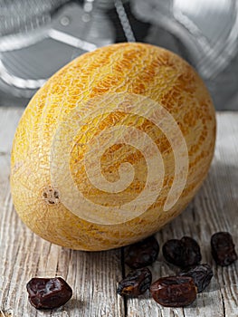 Tasty and juicy melon on a white vintage wooden background. Near ripe dates fruit. Close-up