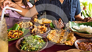 Tasty looking Indonesian food served on the table with a variety of chili sauces, rice, prawns, chicken and omlette