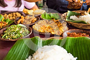 Tasty looking Indonesian food served on the table with a variety of chili sauces, rice, prawns, chicken and omlette