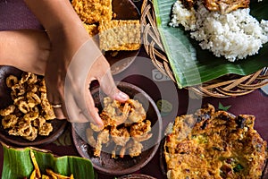 Tasty looking Indonesian food served on the table with a variety of chili sauces, rice, prawns, chicken and omlette.