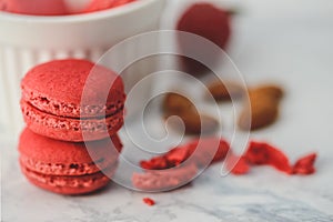 Tasty macarons in a stylish bowl on white marble background. Minimalist concept of style and french chic and selective