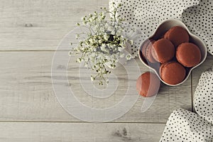 Tasty macarons in a stylish bowl on white marble background. Minimalist concept of style and french chic and selective