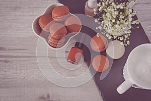 Tasty macarons in a stylish bowl on white wooden background. Minimalist concept of style and french chic and selective