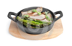 Tasty meat with asparagus and sprouts in portioned frying pan isolated