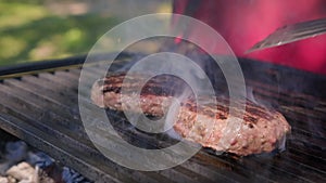 Tasty meat for burger cooked on fiery barbecue grill. Close up of chief cooked oil unhealthy. Beef or pork meat barbecue