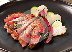 Tasty medium raw sliced roast beef with vegetables