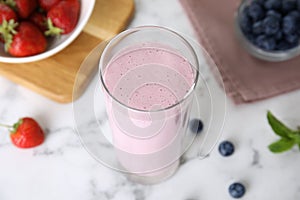 Tasty milk shake and berries on light table