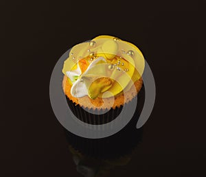 Tasty muffin with buttercream on glass background