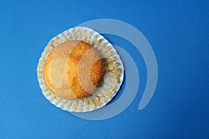 Tasty muffin closeup on a blue paper background