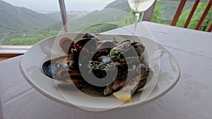 Tasty mussels on a table with a glass of a fine white wine.