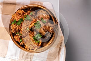 Tasty Nigerian Jollof Rice served and decorated with some green spices and chicken