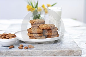 Tasty oatmeal almond cookies with jar of milk on the old marble table beautiful close-up picture light white background