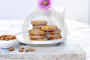 Tasty oatmeal almond cookies with jar of milk on the old marble table beautiful close-up picture light white background