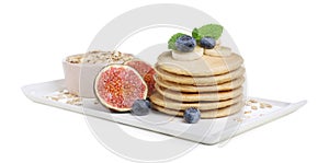 Tasty oatmeal pancakes and ingredients on white background