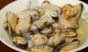 Tasty oiled pickled mussels iin a plate on the table