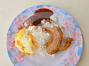 Tasty but oily crispy Fried chicken with nasi lemak white rice photo