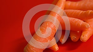 Tasty orange carrots on a red background