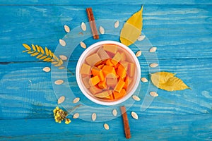 Tasty pumpkin in bowl on the blue background. Food concept.