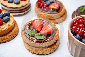 Tasty organic rusks with different toppings on light grey table, closeup