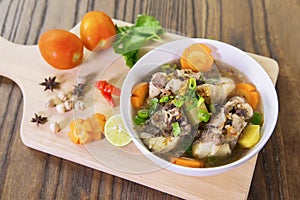 Tasty oxtail soup on wooden table