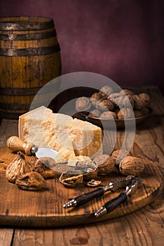 Tasty Parmesan and walnuts on wooden chopping board