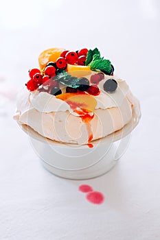 Tasty Pavlova dessert with white meringue, cream and fruit