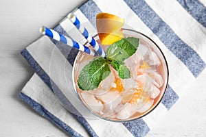 Tasty peach cocktail in glass on table, top view