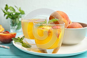 Tasty peach cocktail in glasses on table