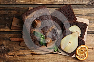 Tasty pear bread with mint, cinnamon and dried orange slices on wooden table. Homemade cake