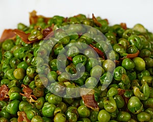 Tasty Peas with ham in a white dish. Close up view