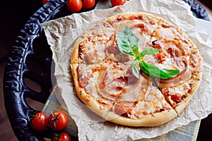 Tasty pizza with becon topped leaf of basil