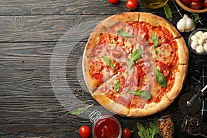 Tasty pizza and ingredients on wooden background