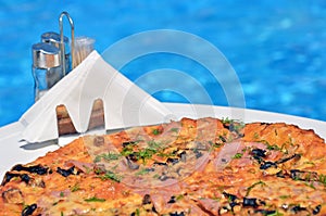 Tasty pizza on the swimming pool background