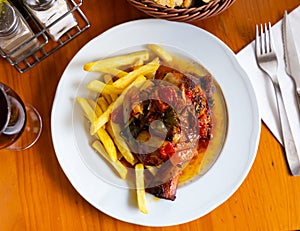 Tasty pork knuckle with potatoes and stewed peppers served