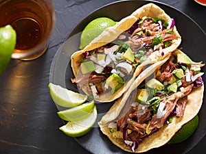 Tasty pork street tacos with onion, cilantro, avocado, and red cabbage photo