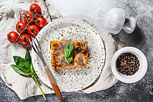 Tasty portion of Italian meat lasagna with melted mozzarella. Gray background. Top view