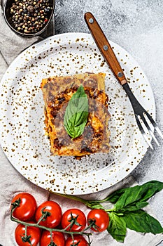 Tasty portion of Italian meat lasagna with melted mozzarella. Gray background. Top view