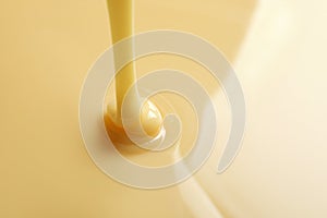 Tasty pouring condensed milk as background, space for text