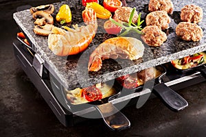 Tasty prawn tails cooking on a raclette grill