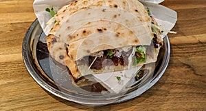 Tasty protein meal food kebab in pita bread and salad served on a table in restaurant as nutritious lunch or dinner