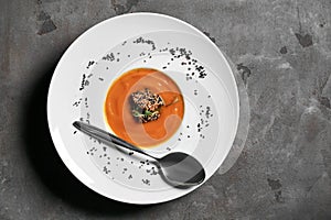 Tasty pumpkin cream soup with fish on grey table