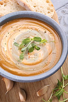 Tasty pumpkin soup with microgreens served on table, closeup