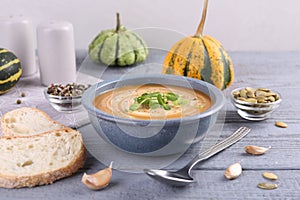 Tasty pumpkin soup served on grey wooden table