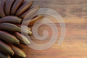 Tasty purple bananas on wooden table, above view. Space for text